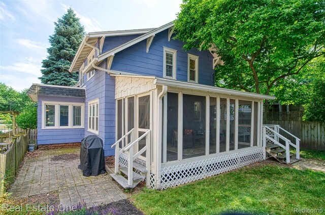 904 Michigan Ave, East Lansing, MI 48823 - rear view of property featuring a fenced backyard, a sunroom, and a patio area