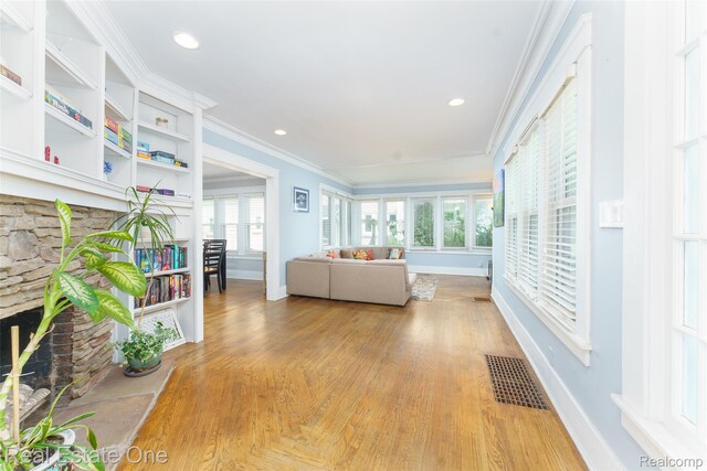 904 Michigan Ave, East Lansing, MI 48823 - living area with light wood-style floors, crown molding, a stone fireplace, and recessed lighting