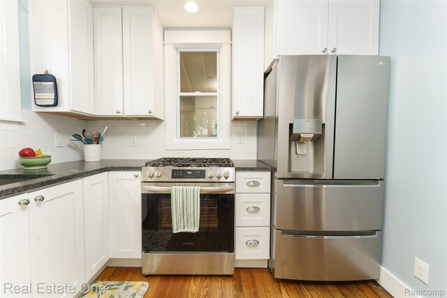 904 Michigan Ave, East Lansing, MI 48823 - kitchen featuring appliances with stainless steel finishes, white cabinetry, decorative backsplash, light wood-style floors, and recessed lighting