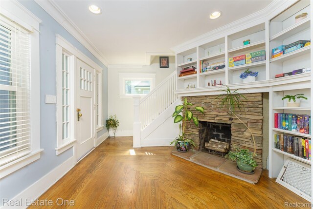 904 Michigan Ave, East Lansing, MI 48823 - living room with stairway, ornamental molding, a stone fireplace, and recessed lighting
