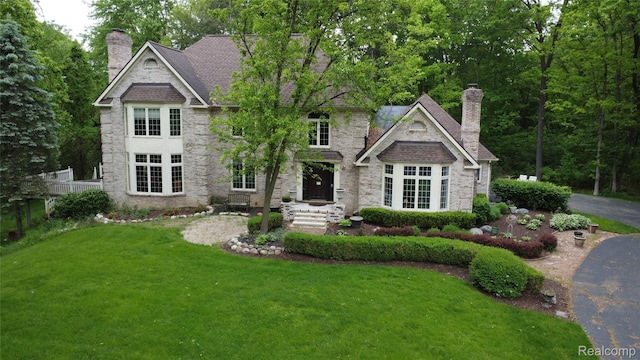 4270 Argenta Dr, Brighton, MI 48116 - view of front of property with a chimney, a front yard, and stone siding