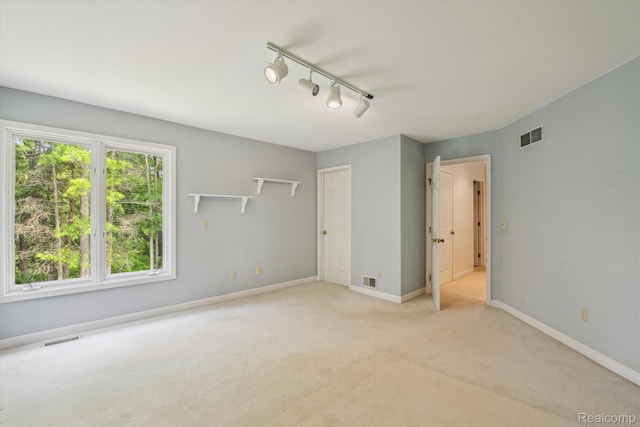 4270 Argenta Dr, Brighton, MI 48116 - unfurnished bedroom featuring light colored carpet and rail lighting