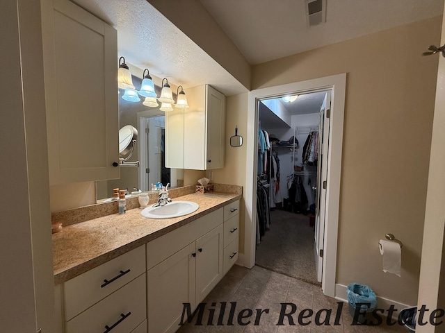 618 Riverwalk St, Hastings, MI 49058 - bathroom featuring vanity, a walk in closet, and tile patterned floors