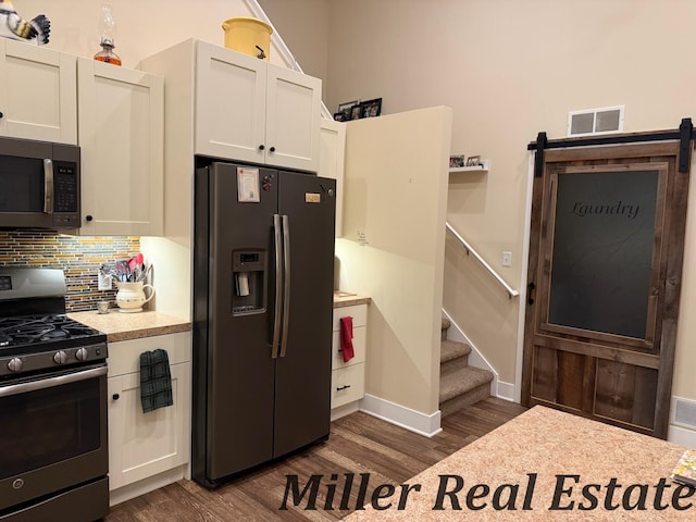 618 Riverwalk St, Hastings, MI 49058 - kitchen featuring appliances with stainless steel finishes, light countertops, dark wood-style flooring, decorative backsplash, and white cabinetry