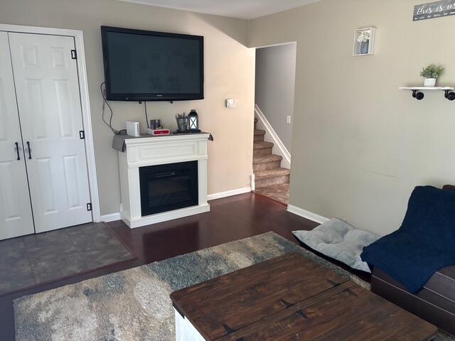 137 Apperson Rd, Battle Creek, MI 49015 - living room featuring stairway, wood finished floors, and a glass covered fireplace
