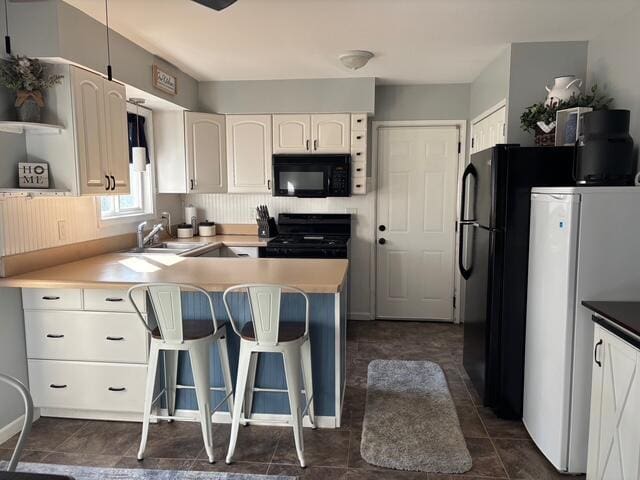 137 Apperson Rd, Battle Creek, MI 49015 - kitchen featuring black microwave, range, a peninsula, open shelves, and white cabinetry