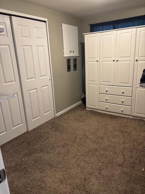 137 Apperson Rd, Battle Creek, MI 49015 - unfurnished bedroom featuring dark carpet and baseboards