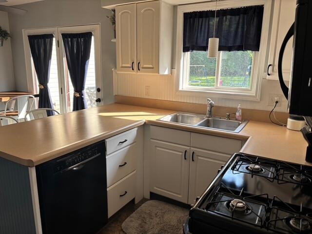 137 Apperson Rd, Battle Creek, MI 49015 - kitchen featuring black appliances, a peninsula, white cabinets, and light countertops