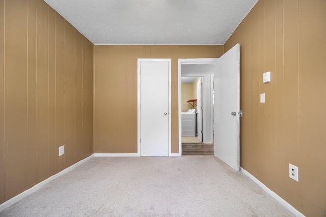 6353 Birchwood Dr, Lake, MI 48632 - unfurnished bedroom featuring light carpet, a textured ceiling, and wood walls