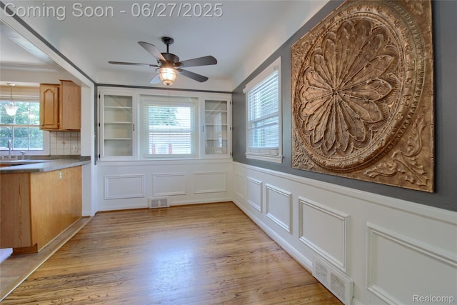 2371 Allard Ave, Grosse Pointe Woods, MI 48236 - unfurnished dining area featuring plenty of natural light, ceiling fan, light wood-style flooring, a wainscoted wall, and a decorative wall