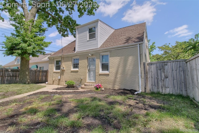 2371 Allard Ave, Grosse Pointe Woods, MI 48236 - back of house featuring entry steps, brick siding, a shingled roof, and a fenced backyard