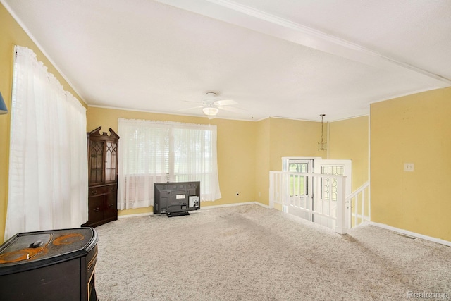367 N Morrison Rd, West Branch, MI 48661 - carpeted spare room with a wood stove, a ceiling fan, and crown molding
