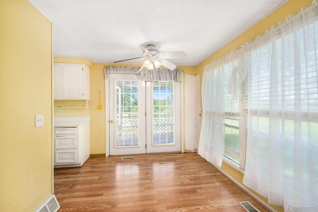 367 N Morrison Rd, West Branch, MI 48661 - unfurnished dining area featuring light wood finished floors, ceiling fan, and a textured ceiling