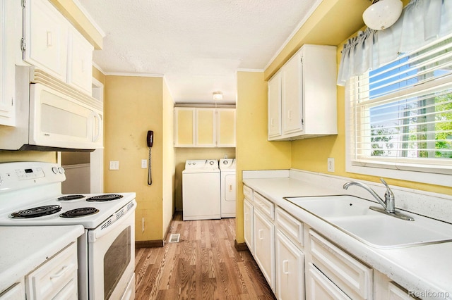 367 N Morrison Rd, West Branch, MI 48661 - kitchen featuring white appliances, washer and clothes dryer, light wood-type flooring, light countertops, and a textured ceiling