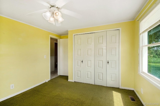 367 N Morrison Rd, West Branch, MI 48661 - unfurnished bedroom featuring dark colored carpet, a closet, ornamental molding, and ceiling fan
