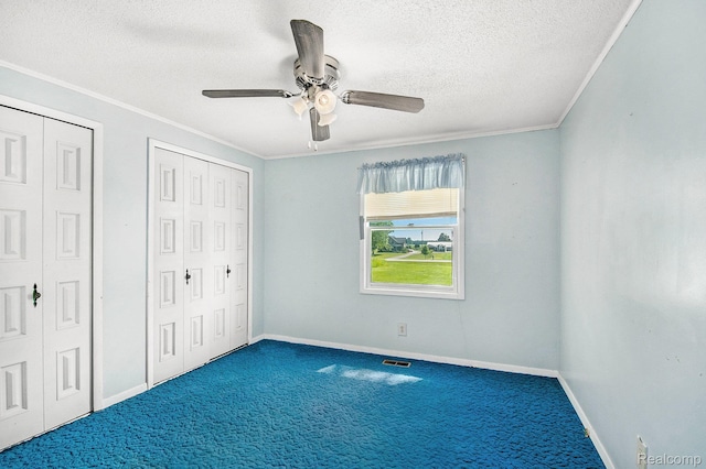 367 N Morrison Rd, West Branch, MI 48661 - unfurnished bedroom featuring carpet floors, a textured ceiling, ornamental molding, multiple closets, and ceiling fan