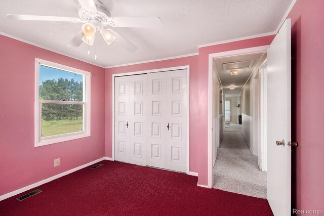 367 N Morrison Rd, West Branch, MI 48661 - unfurnished bedroom with dark carpet, crown molding, a closet, a ceiling fan, and a textured ceiling