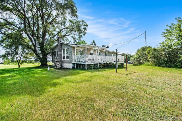 367 N Morrison Rd, West Branch, MI 48661 - back of property with a chimney, a lawn, and a deck