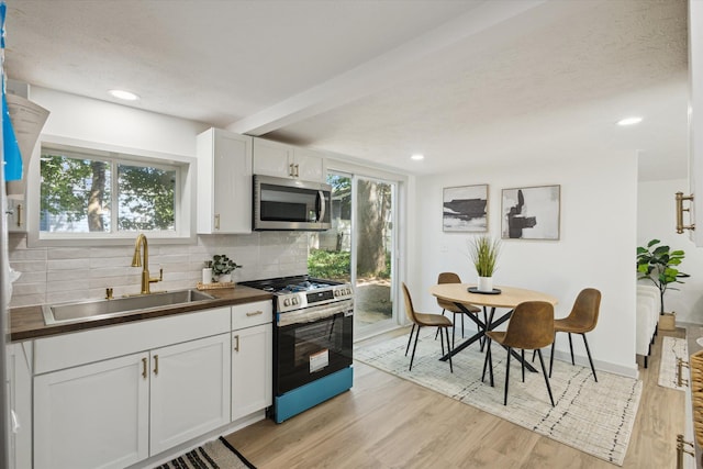 3736 Michael Ave SW, Wyoming, MI 49509 - kitchen with stainless steel appliances, backsplash, white cabinetry, light wood-type flooring, and recessed lighting