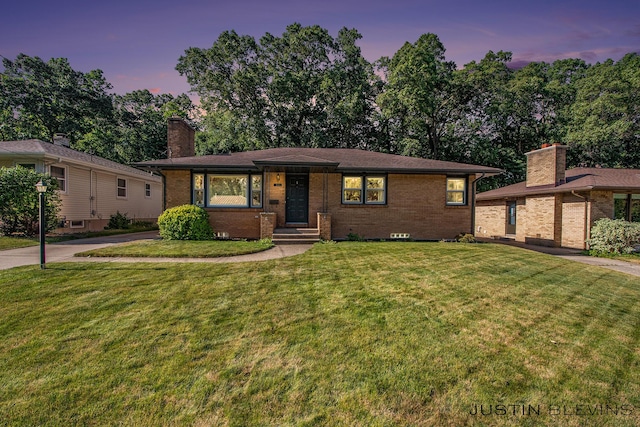 1538 10th St NW, Grand Rapids, MI 49504 - view of front of house with brick siding, a chimney, and a lawn