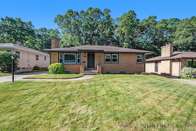 1538 10th St NW, Grand Rapids, MI 49504 - view of front facade with brick siding, a front yard, and a chimney