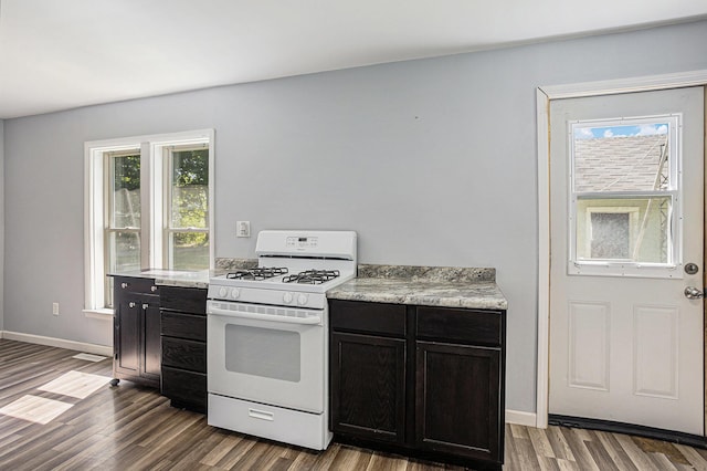 204 W Clay St, Sherwood, MI 49089 - kitchen featuring white range with gas cooktop, dark wood-style flooring, dark cabinets, and light countertops