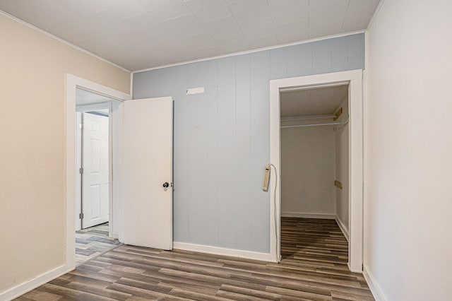 204 W Clay St, Sherwood, MI 49089 - unfurnished bedroom featuring dark wood finished floors, ornamental molding, a walk in closet, and a closet