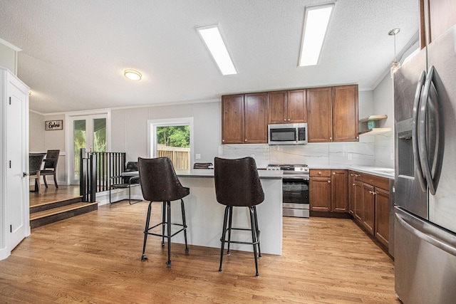 80150 46th Ave, Coloma, MI 49038 - kitchen with appliances with stainless steel finishes, open shelves, a breakfast bar area, ornamental molding, and light wood finished floors