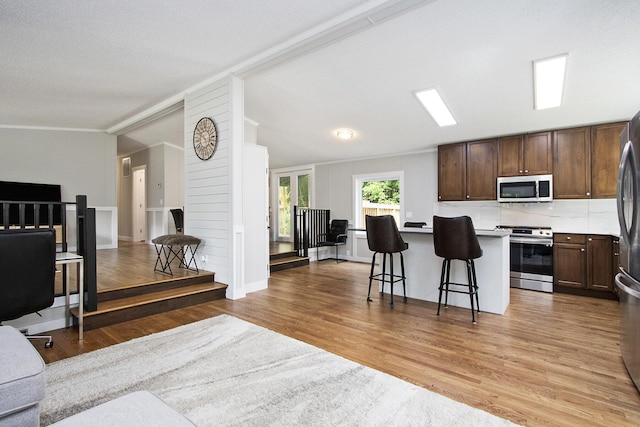 80150 46th Ave, Coloma, MI 49038 - kitchen with stainless steel appliances, open floor plan, a breakfast bar area, ornamental molding, and a center island