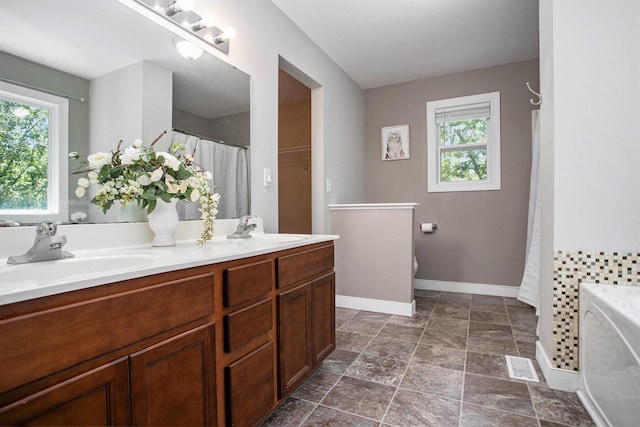 6061 Equestrian Woods Ct, Kalamazoo, MI 49009 - full bath with plenty of natural light, double vanity, stone finish floors, and a bath