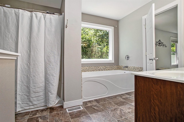 6061 Equestrian Woods Ct, Kalamazoo, MI 49009 - full bathroom with plenty of natural light, vanity, a bath, and stone finish floors