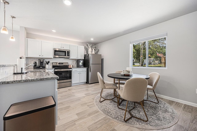 374 Lotz Ct, Wayland, MI 49348 - kitchen featuring stainless steel appliances, decorative backsplash, light stone counters, white cabinetry, and recessed lighting