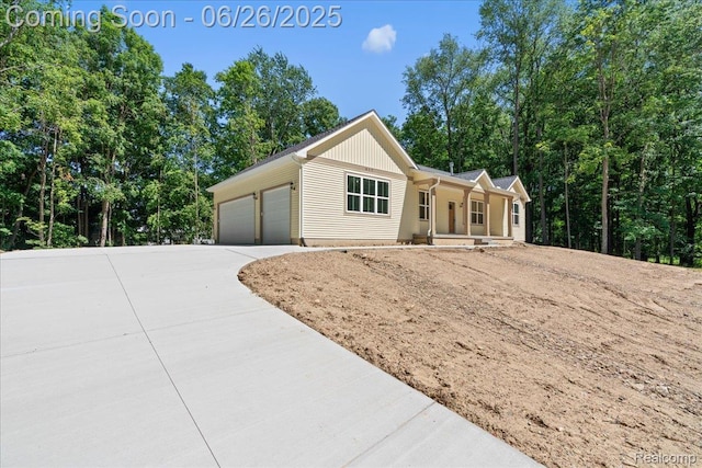 917 Chickasaw Dr, Mason, MI 48854 - ranch-style home featuring driveway, covered porch, and a garage