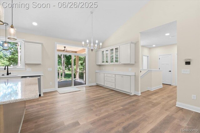 917 Chickasaw Dr, Mason, MI 48854 - kitchen featuring white cabinetry, healthy amount of natural light, light wood-style flooring, vaulted ceiling, and recessed lighting