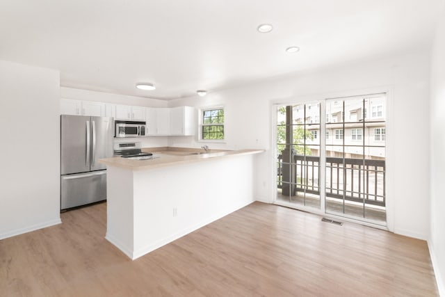 3046 Barclay Way, Ann Arbor, MI 48105 - kitchen with stainless steel appliances, white cabinetry, light wood-type flooring, light countertops, and a peninsula