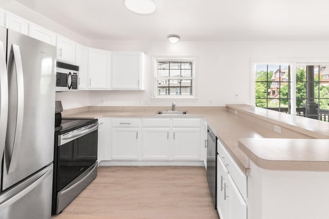3046 Barclay Way, Ann Arbor, MI 48105 - kitchen featuring appliances with stainless steel finishes, a peninsula, light countertops, and white cabinets