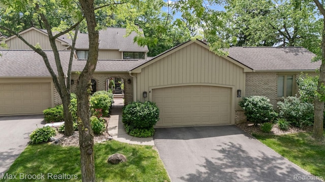 1122 Meadowglen Ct, Bloomfield Hills, MI 48304 - view of front facade featuring brick siding, a shingled roof, a garage, and asphalt driveway