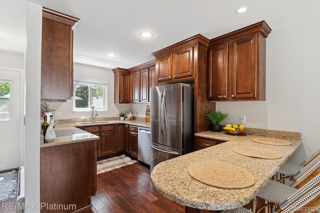 5959 Alan Dr Unit 53, Brighton, MI 48116 - kitchen with stainless steel appliances, a peninsula, dark wood-type flooring, light stone counters, and recessed lighting