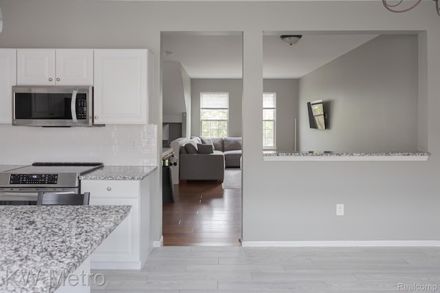 25493 Saint James, Southfield, MI 48075 - kitchen with appliances with stainless steel finishes, light wood-style flooring, white cabinetry, light stone countertops, and tasteful backsplash