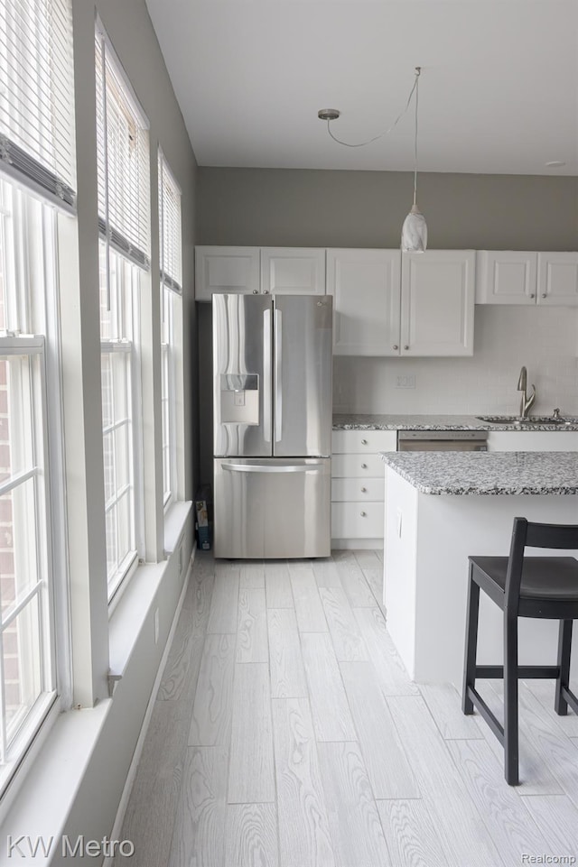 25493 Saint James, Southfield, MI 48075 - kitchen featuring stainless steel fridge with ice dispenser, light wood-style floors, white cabinets, and light stone countertops
