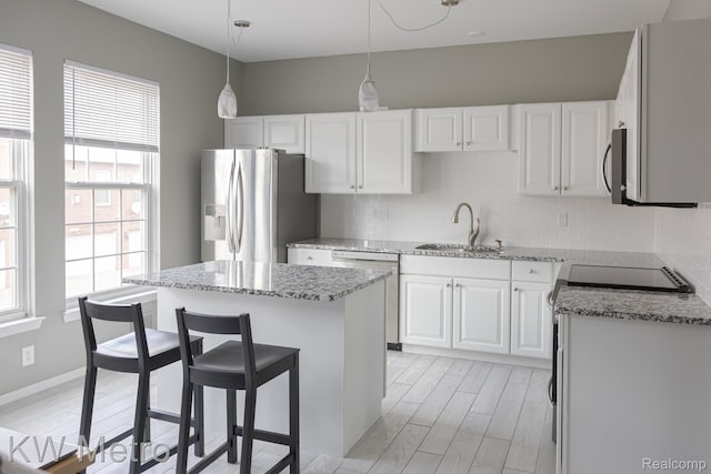 25493 Saint James, Southfield, MI 48075 - kitchen featuring stainless steel appliances, tasteful backsplash, light stone countertops, white cabinetry, and a kitchen island