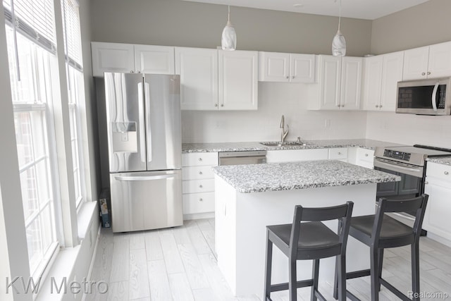 25493 Saint James, Southfield, MI 48075 - kitchen with stainless steel appliances, white cabinetry, a kitchen bar, a center island, and light stone counters