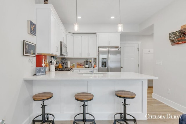 605 Bedford Falls Dr, Sparta, MI 49345 - kitchen featuring appliances with stainless steel finishes, a peninsula, light countertops, white cabinetry, and recessed lighting
