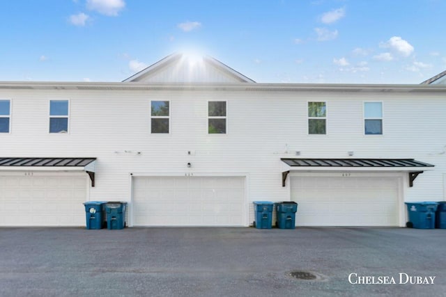605 Bedford Falls Dr, Sparta, MI 49345 - back of house featuring a standing seam roof, a metal roof, and a garage