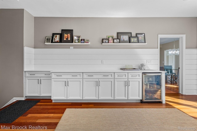 9239 Silverside, South Lyon, MI 48178 - indoor bar with wine cooler, dark wood finished floors, and a chandelier