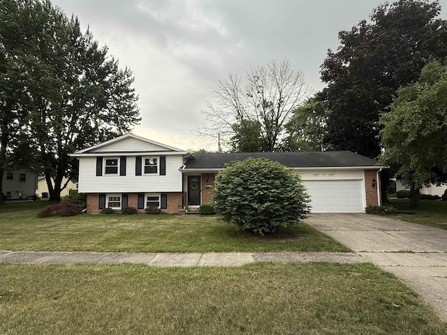 808 Stevens Dr, Owosso, MI 48867 - split level home featuring brick siding, concrete driveway, a front lawn, and a garage