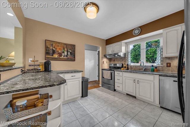2425 Avondale St W, Sylvan Lake, MI 48320 - kitchen with stainless steel appliances, under cabinet range hood, white cabinets, decorative backsplash, and light tile patterned flooring