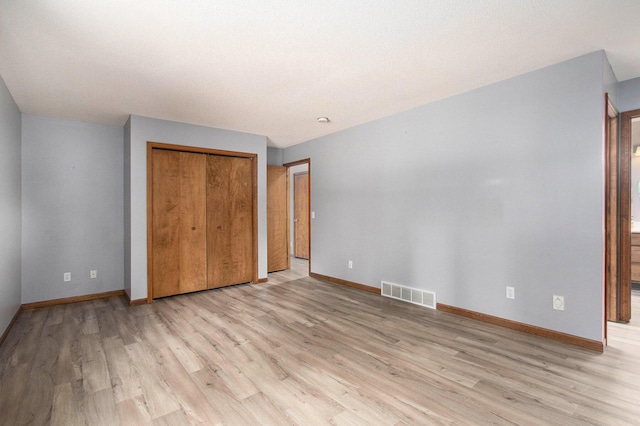 1067 Aspen Dr, Norton Shores, MI 49441 - unfurnished bedroom featuring light wood-style floors and a closet