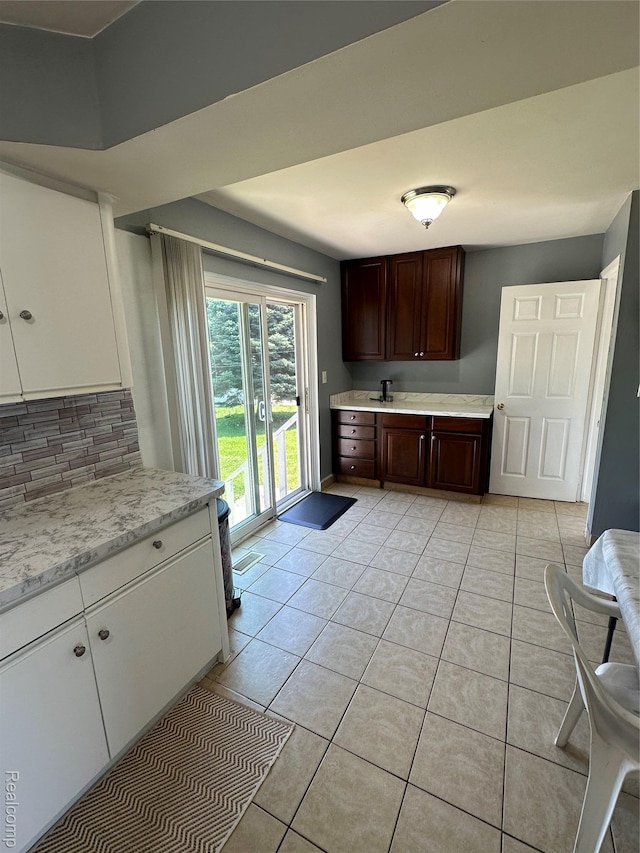 32302 Ryan Rd, Warren, MI 48092 - kitchen with decorative backsplash, light tile patterned flooring, dark brown cabinetry, and white cabinetry