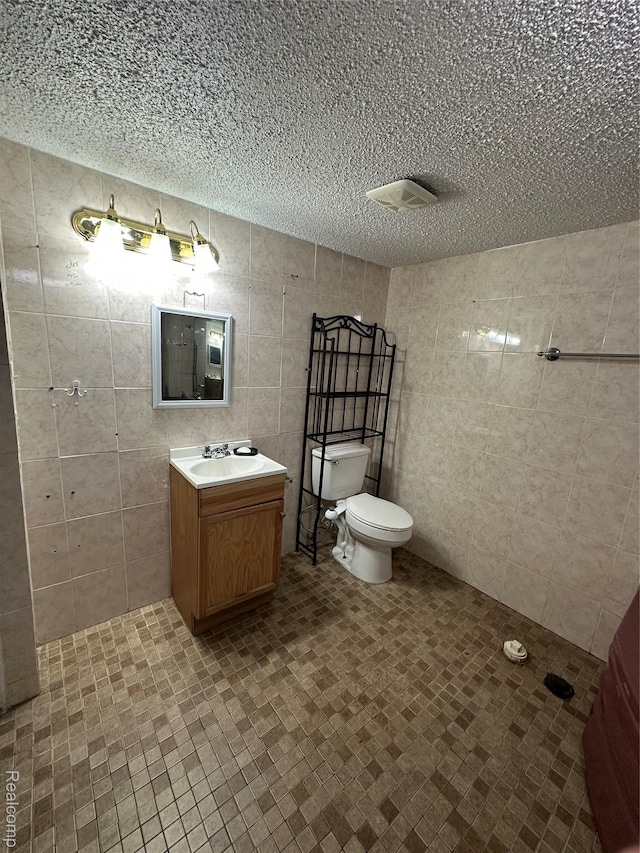32302 Ryan Rd, Warren, MI 48092 - bathroom with vanity, a textured ceiling, and tile walls